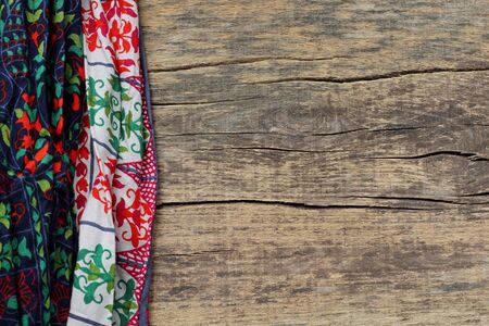 Wooden background with Indian ethnic fabric. Texture of Indian colored fabric. Top view. Copy space.の写真素材