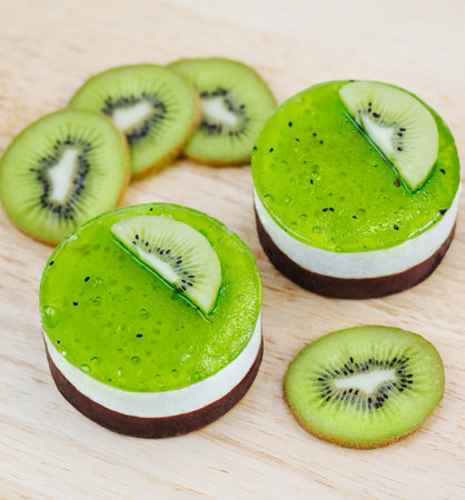 Green cake with kiwi on a wooden butcherの写真素材