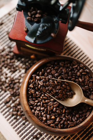 coffee beans in a wooden plate with a coffee grinderの写真素材