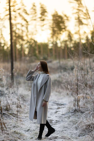 portrait of a beautiful woman on a frosty day. First snowの写真素材
