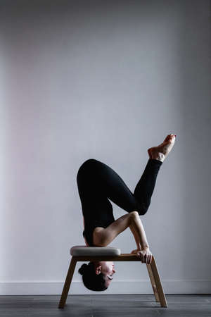Girl doing fit exercises on pilates yoga shoulder stand chair Inversionの写真素材