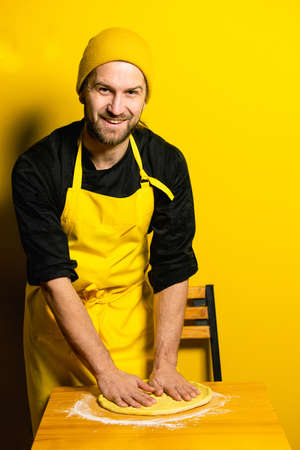 young attractive chef cook indian naan on yellow backgroundの写真素材