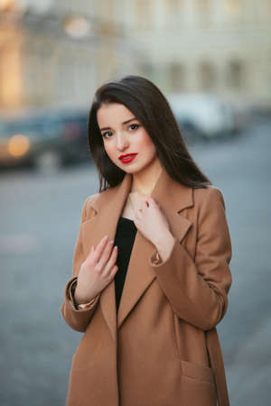 girl in coat in the street at sunriseの写真素材