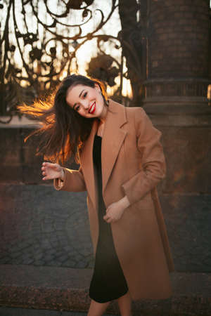 girl in coat in the street at sunriseの写真素材