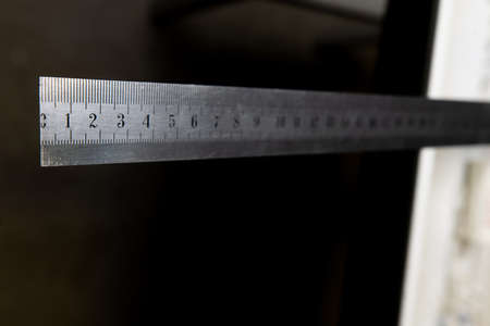 iron ruler with numbers on black backgroundの写真素材