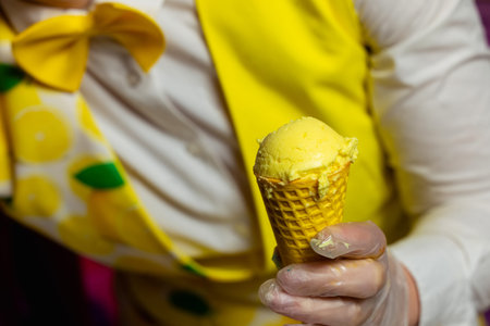 Hands of the ice cream man scooping strawberry ice cream into the waffle coneの写真素材