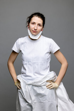 tired doctor female in a protective suit on the floor, exhausted in the fight against a pandemic...
