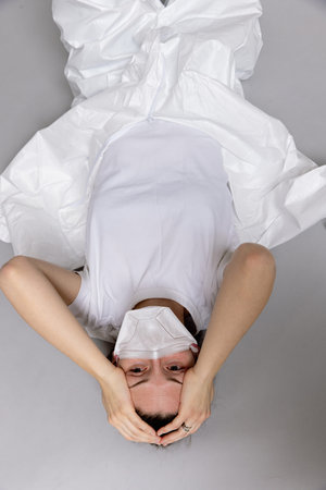 tired doctor female in a protective suit on the floor, exhausted in the fight against a pandemic...