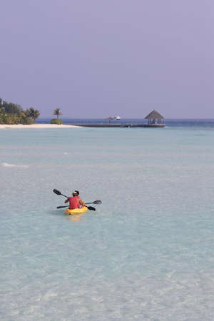 Kayaking session in the Maldives. What is the best way to enjoy this amazing water and discover a sandbank. kayak is transparent to see all the beautiful fishes duringの写真素材