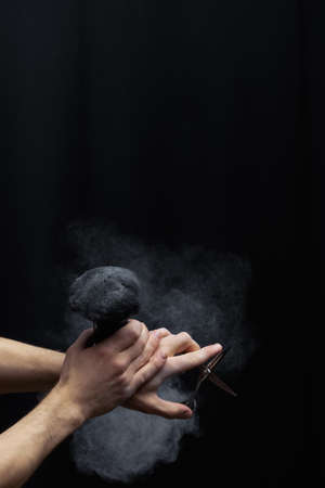 barber is holding a brush for powder hairdresser and scissorの写真素材