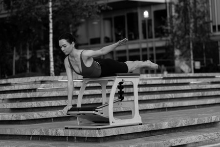 Pilates reformer chair woman fitness yoga gym exercise. Correction of musculoskeletal system,...