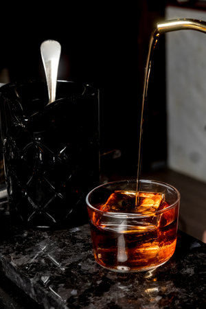 bartender pours alcohol from kettle to the cupの写真素材