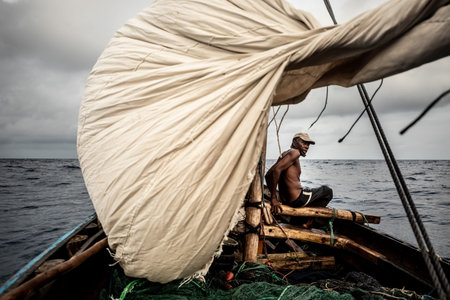 Night fishing. A man pulls out a fishing net at night. Indian Oceanの写真素材