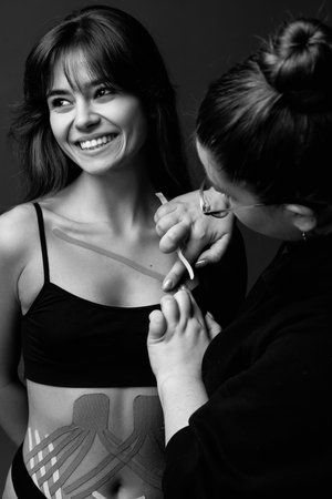 Aesthetic tape on patient chest. Young female. Post traumatic rehabilitation, sport physical therapy, recovery concept, alternative medicine.の写真素材