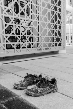 hard work shoes in Dubai street construction worker Conceptual shooting of shoes. Old shabby shoes cementDirty old working boots.の写真素材