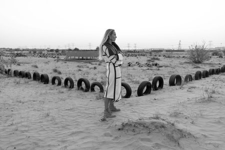 recycle tyre rubber A girl in a faux fur coat in the desert. Animal protection. Ecological concept....