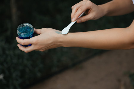 Moisturizer jar with tubes of lotion on black background. Spa massage cream on wet slate ready for therapy. Natural fresh facial moisturizer in a glass, cosmetic and spa concept. Healthy lifeの写真素材
