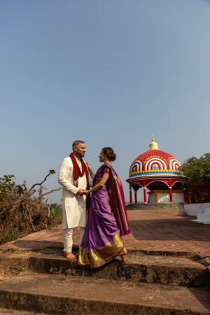 Wedding of a couple from Europe in India. A light skinned man in a traditional Indian men. white skin. Bride in beautiful sari with mehendi. Caucasian marriage. International couple.Lovely couple fitの写真素材