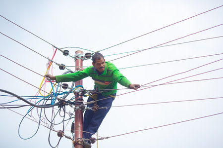 India, Dharmasala 2023 Jmuyary: electrician standing on a cable car to repair the power supply systemのeditorial素材