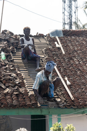 February 14, 2023, Chennai city, India: Two local men are roofing the houseのeditorial素材