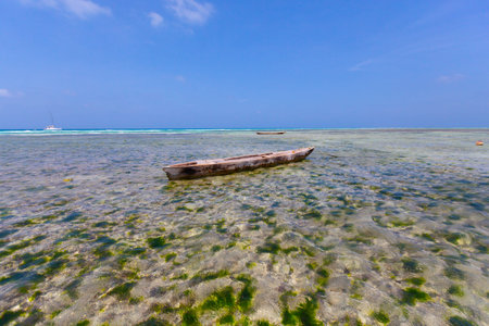 The scene depicts an aged wooden boat gently floating on the crystal-clear water
