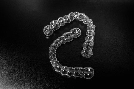 Invisible dental teeth brackets tooth aligners on black background.の写真素材
