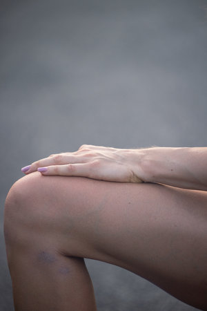 A hand is resting on the girls knee.の写真素材