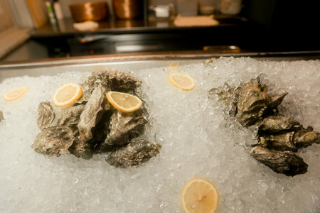 Fresh opened oyster offered as top view on crushed iceの写真素材
