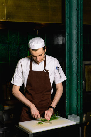 chef preparing food in the kitchen at the restaurant cutting cook hands hotel man male knife