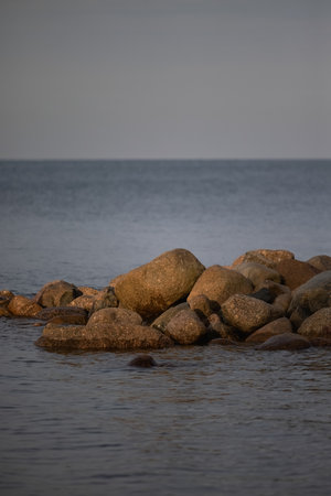 Calm blue sea and big rocks on the beach.の写真素材