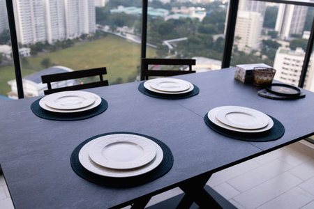 A dining area with a view of the city, consisting of modern chairs and table.の写真素材