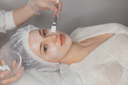 process of applying a cream before a facial aesthetic treatmentの写真素材