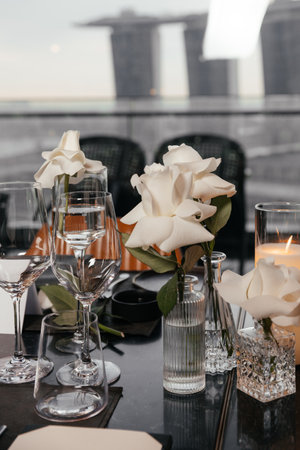 Table decor in a restaurant with a white rose in the background and a viewの写真素材