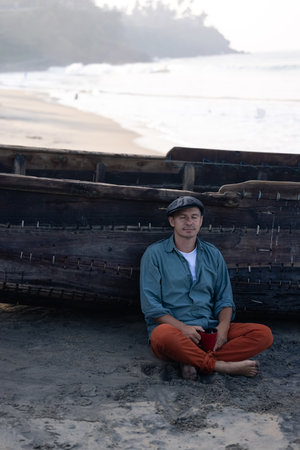 A young attractive man, against the backdrop of his fishing boatの写真素材