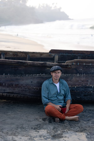 A young attractive man, against the backdrop of his fishing boatの写真素材