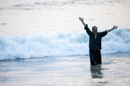 A man is standing in the ocean.の写真素材