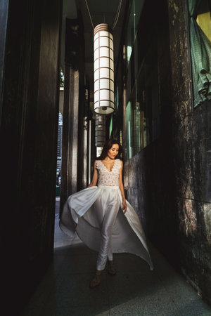 photograph features a stunning Asian woman in a unique white wedding dress-trouser suitの写真素材