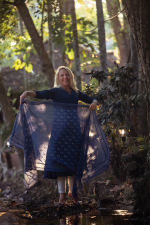 Beautiful mature woman in blue dress at sunset, natural elegance and conceptの写真素材
