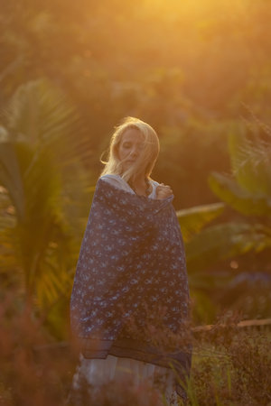 Beautiful mature woman in blue dress at sunset, natural elegance and conceptの写真素材