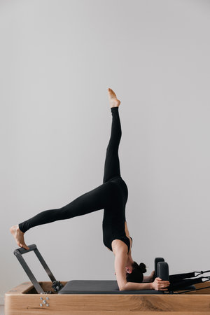 Pilates reformer training machine. sporty woman exercising gymの写真素材