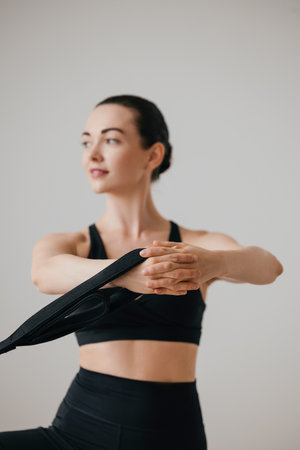 Slim woman holding pilates machine strap during workoutの写真素材