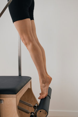 Pilates reformer chair with natural wood details used for training exerciseの写真素材