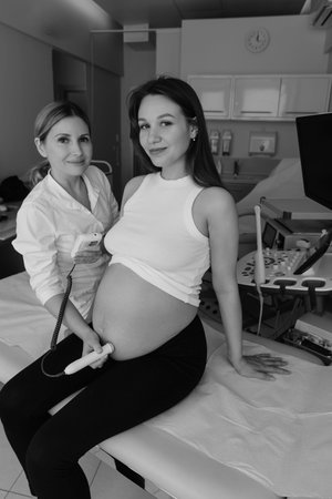female gynecologist using fetal doppler with pregnant patient during examination