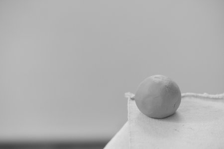 Round clay ball for pottery and sculpting on a blurred background. Raw ceramic materialの写真素材
