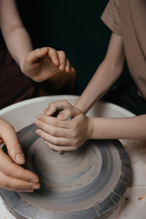 Potter shaping a ceramic artwork on a wheel. Hands in clay. Artistic pottery workshopの写真素材