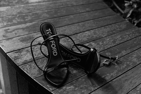 NEW YORK, NY - SEPTEMBER 05 2022: Luxurious Tom Ford shoes on a wet bench in Central Park, New York.のeditorial素材