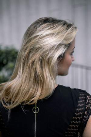 Portrait of beautiful young blond woman with long wavy hair back view