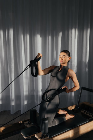 Pilates reformer training machine in use by female athlete