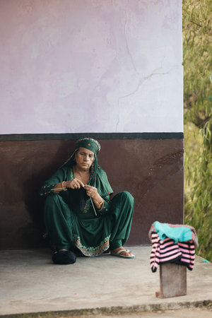 04 of September 2025 India: Indian woman in Himachal Pradesh style clothes sitting with pile of...