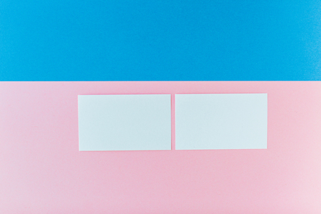 Two business cards on the pink and blue backgroundの写真素材